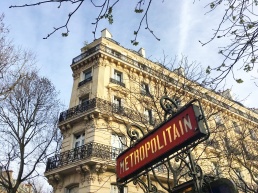 Call Me Katie - Instagramable Spots in Paris - Metro sign with a Parisian building in the background